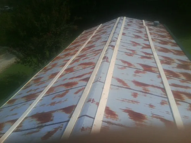 Rusted metal roof panels with new wood purlins before replacement — Storm Damage Roof Repair in Lisle by Roofing Brothers